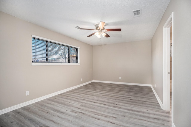 spare room featuring a textured ceiling, light hardwood / wood-style flooring, and ceiling fan