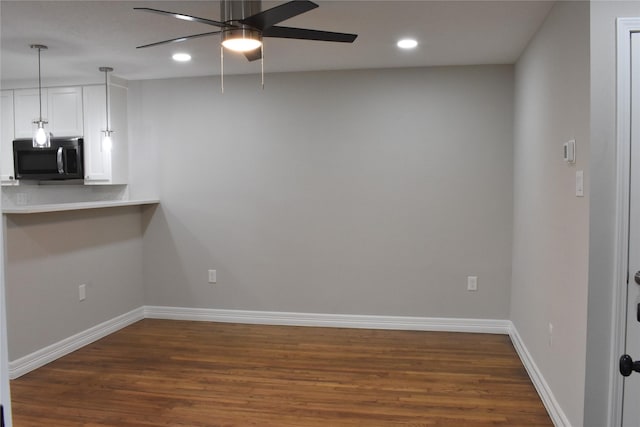 empty room with dark hardwood / wood-style floors and ceiling fan