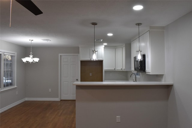 kitchen featuring white cabinets, sink, hanging light fixtures, dark hardwood / wood-style flooring, and kitchen peninsula