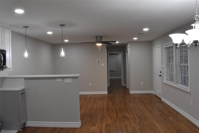 interior space with dark hardwood / wood-style floors and ceiling fan with notable chandelier