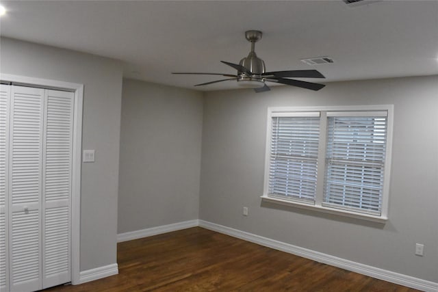 unfurnished bedroom with ceiling fan, a closet, and dark hardwood / wood-style floors