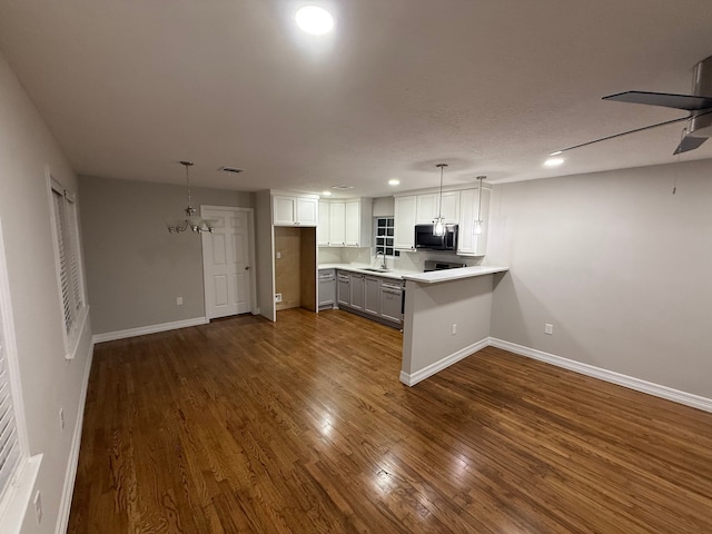 kitchen featuring kitchen peninsula, white cabinetry, wood-type flooring, and decorative light fixtures