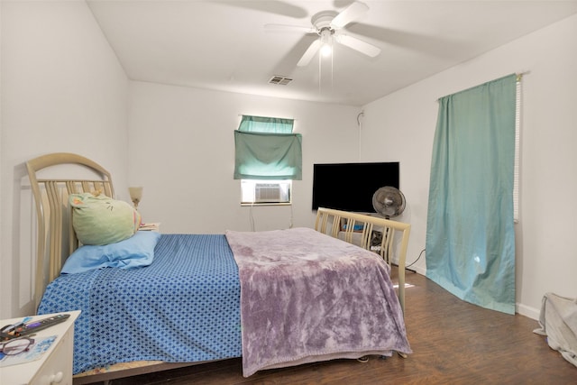 bedroom with cooling unit, ceiling fan, and dark wood-type flooring