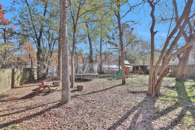 view of yard featuring a playground and a trampoline