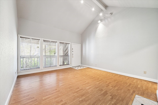 unfurnished living room with light hardwood / wood-style flooring, beamed ceiling, and high vaulted ceiling