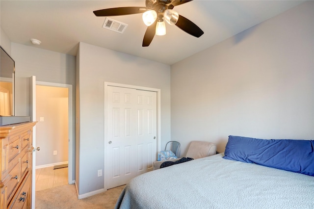 carpeted bedroom with ceiling fan and a closet