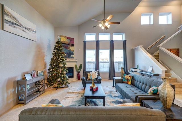 carpeted living room featuring high vaulted ceiling, ceiling fan, and a wealth of natural light