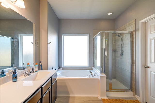 bathroom with hardwood / wood-style floors, vanity, and independent shower and bath