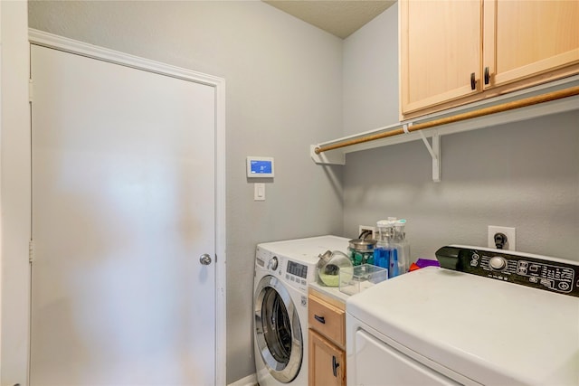 clothes washing area featuring cabinets, washing machine and dryer, and a textured ceiling