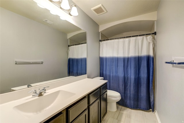 bathroom featuring vanity, toilet, and curtained shower