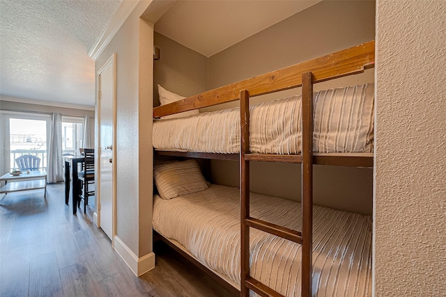 6300 Seawall Blvd Unit 3213, Galveston, TX 77551 - bedroom with wood finished floors and a textured ceiling