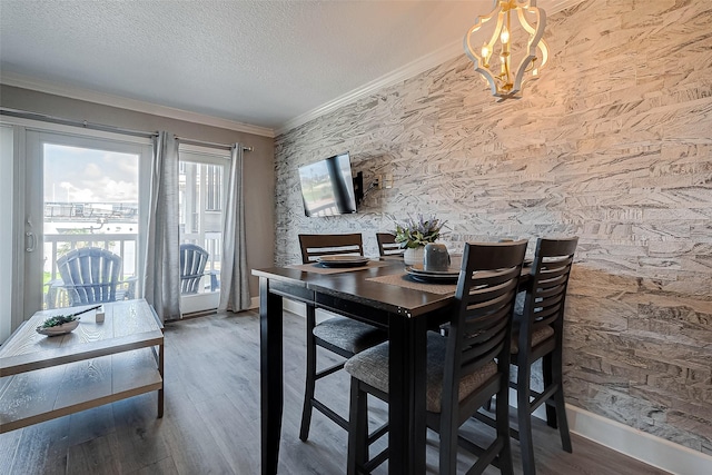 dining space with a chandelier, ornamental molding, a textured ceiling, and hardwood / wood-style flooring