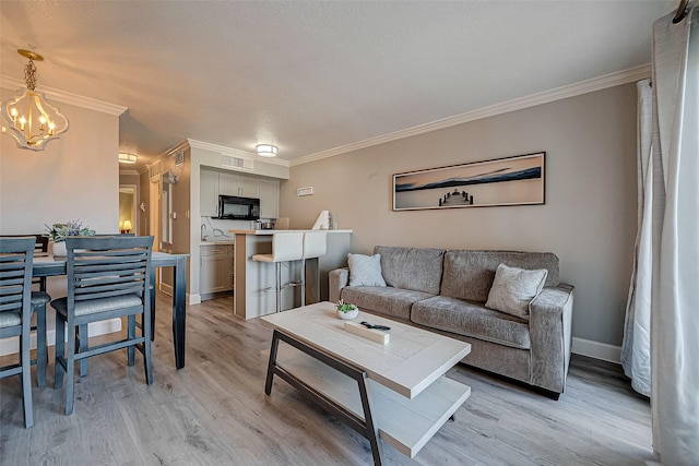 6300 Seawall Blvd Unit 3213, Galveston, TX 77551 - living area featuring light wood finished floors, baseboards, visible vents, a chandelier, and crown molding