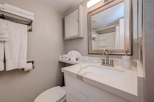 bathroom with vanity, curtained shower, toilet, and a textured ceiling