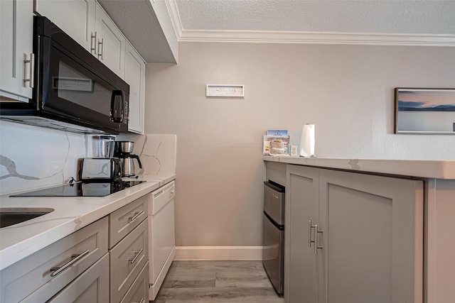 kitchen with black appliances, light hardwood / wood-style flooring, ornamental molding, a textured ceiling, and light stone counters