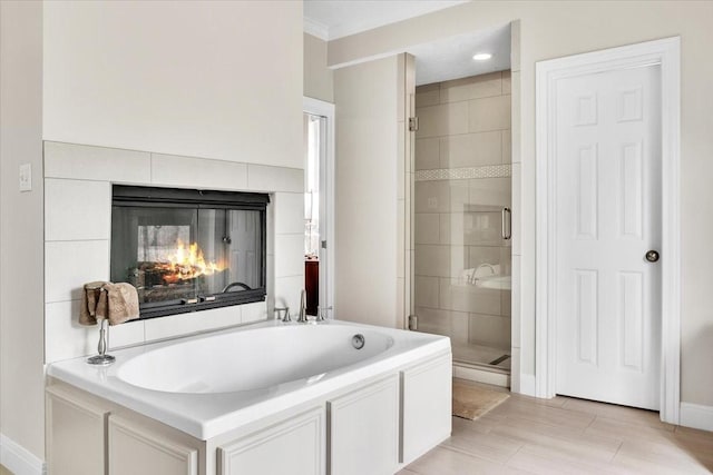 bathroom featuring a multi sided fireplace, crown molding, and independent shower and bath