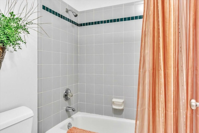 bathroom with shower / bath combination with curtain and toilet