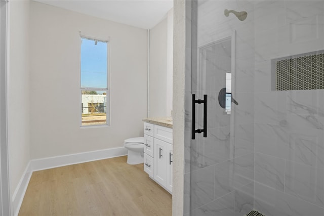 bathroom featuring hardwood / wood-style floors, vanity, toilet, and a shower with door