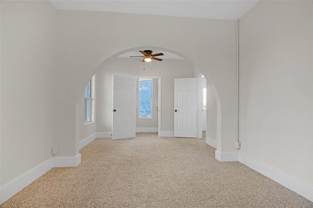 spare room with ceiling fan and light colored carpet