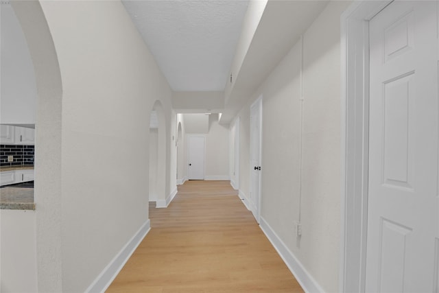 hall featuring a textured ceiling and light wood-type flooring