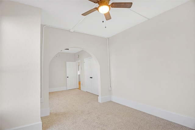 unfurnished room with light colored carpet and ceiling fan