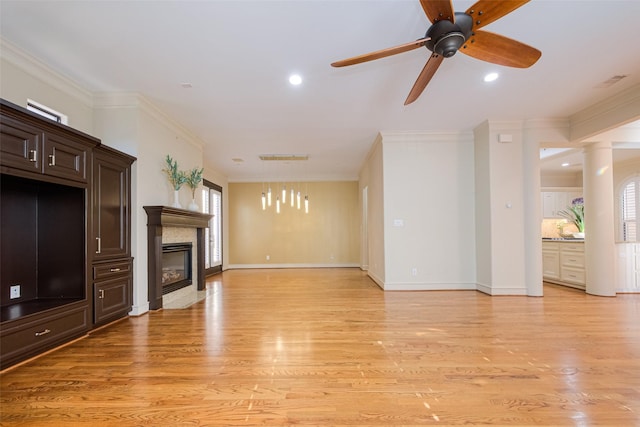 unfurnished living room with light wood-type flooring, crown molding, and a healthy amount of sunlight