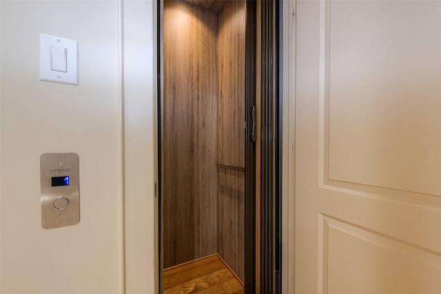 interior details featuring hardwood / wood-style flooring and elevator