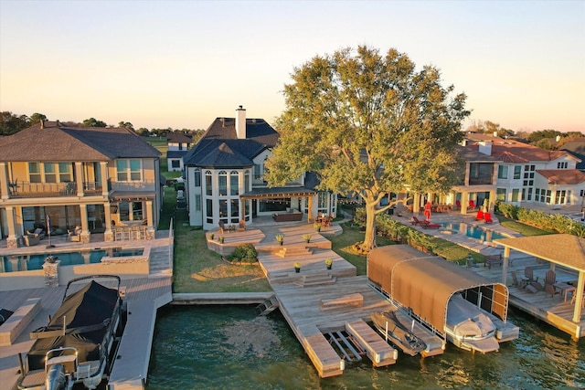 dock area with a water view and a balcony