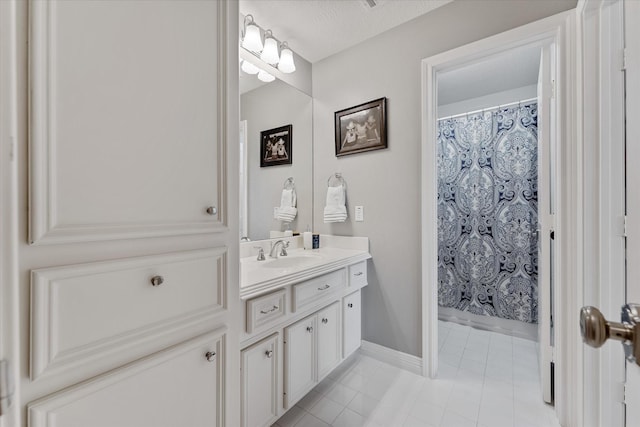 bathroom with tile patterned floors, curtained shower, vanity, and a textured ceiling