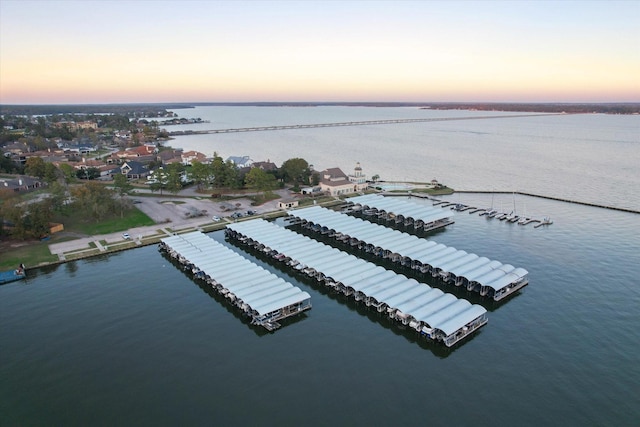 aerial view at dusk featuring a water view