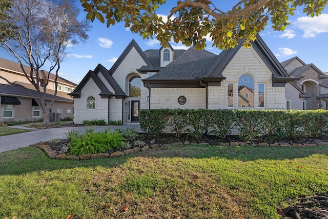 french country inspired facade featuring central AC unit and a front yard