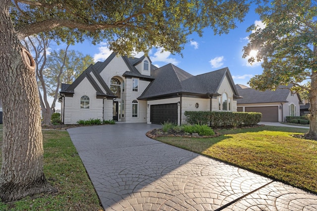 french country home with a front lawn and a garage