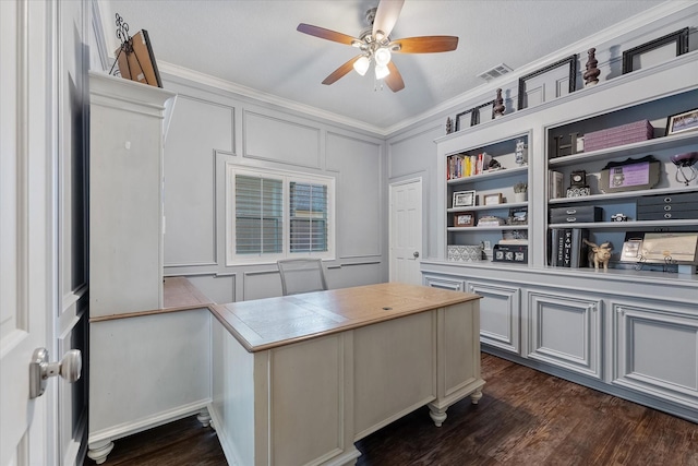 home office with built in shelves, ceiling fan, dark hardwood / wood-style flooring, and crown molding