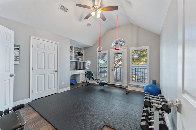 workout room featuring ceiling fan, dark hardwood / wood-style floors, lofted ceiling, and built in shelves