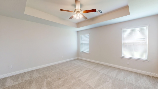 19818 Paros Island Dr, Hockley, TX 77447 - spare room with light colored carpet, a tray ceiling, ceiling fan, and healthy amount of natural light