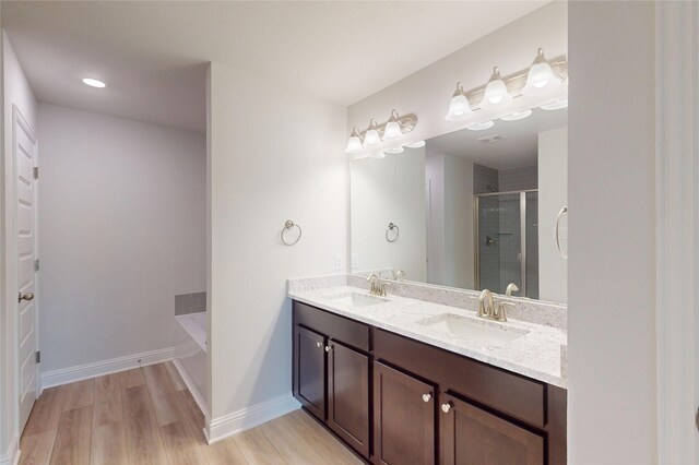 19818 Paros Island Dr, Hockley, TX 77447 - full bath with a stall shower, double vanity, a garden tub, and wood finished floors