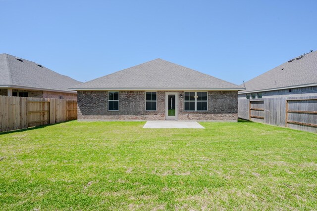 22207 Kastoria Dr, Hockley, TX 77447 - back of property featuring a patio area, a fenced backyard, brick siding, and roof with shingles