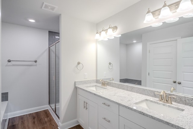 22207 Kastoria Dr, Hockley, TX 77447 - bathroom featuring wood finished floors, double vanity, a shower stall, and recessed lighting