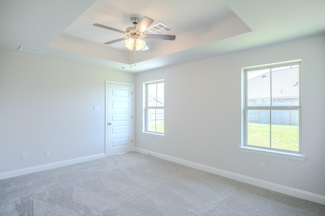 22207 Kastoria Dr, Hockley, TX 77447 - empty room featuring a raised ceiling, light carpet, and ceiling fan