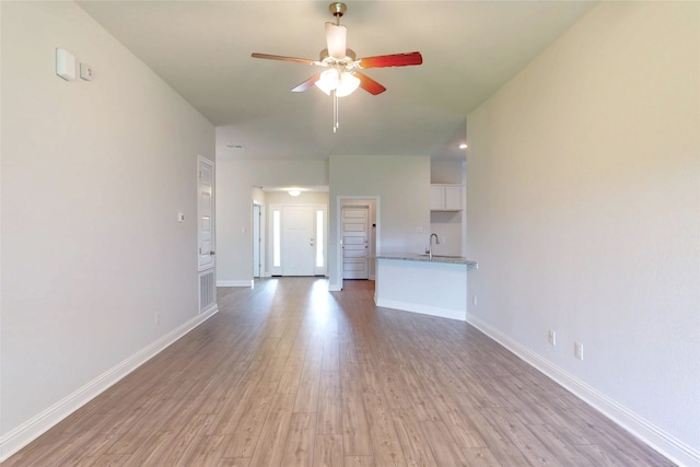 19814 Paros Island Dr, Hockley, TX 77447 - unfurnished living room with ceiling fan and light wood-style flooring