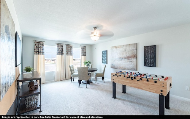 rec room featuring carpet flooring, ceiling fan, and a textured ceiling