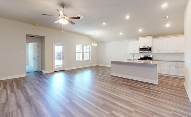 kitchen featuring ceiling fan with notable chandelier, a sink, white cabinets, appliances with stainless steel finishes, and light wood-type flooring