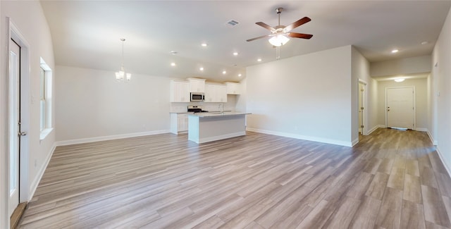 unfurnished living room with light wood-style floors, baseboards, visible vents, and recessed lighting