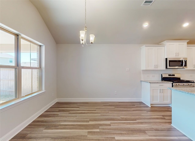 kitchen with lofted ceiling, light wood-type flooring, visible vents, and stainless steel appliances