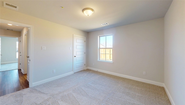 unfurnished room featuring carpet, baseboards, and visible vents