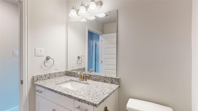 bathroom featuring visible vents, vanity, and toilet