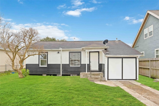 rear view of property featuring a lawn and a garage