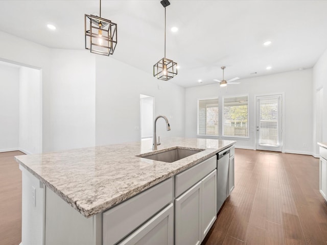 kitchen with dark hardwood / wood-style flooring, sink, hanging light fixtures, and a center island with sink