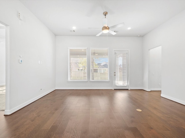 unfurnished living room with ceiling fan, dark wood-type flooring, and a healthy amount of sunlight