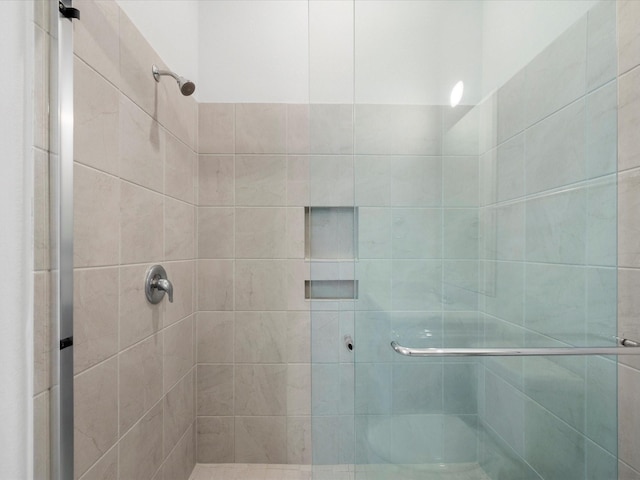 bathroom featuring a shower with shower door